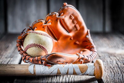 Softball Glove, Ball and Bat Displayed on Wooden Surface
